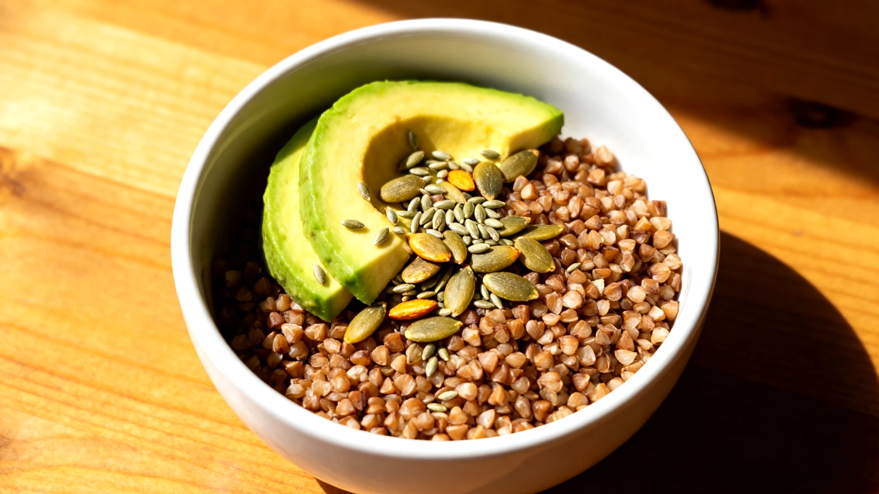Buchweizen-Avocado-Bowl mit gerösteten Kürbiskernen und Hanfsamen"